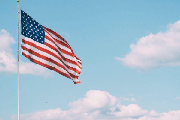 flag of U.S.A. under white clouds during daytime